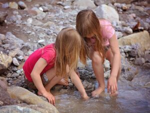 Two girls playing in a stream.