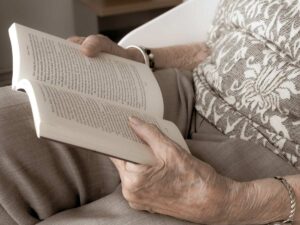 An elderly woman reading a book.