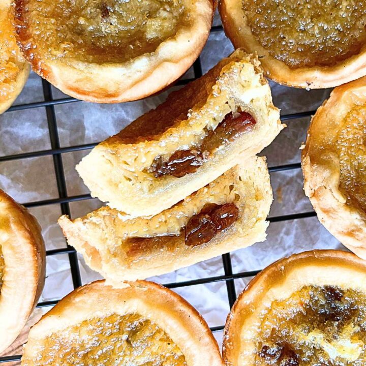 A group of buttertarts on a wire rack. Once is cut in half.