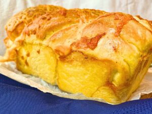 A side view of a loaf of cheese bread.