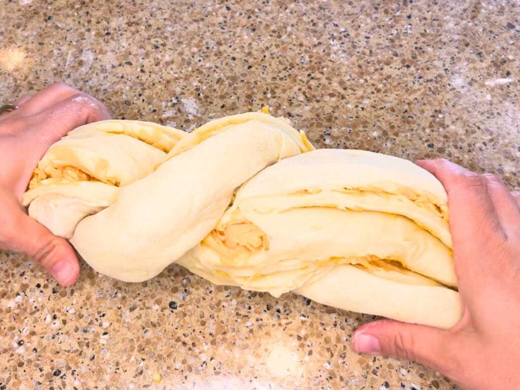 Some dough with cheese inside has been twisted to form a loaf.