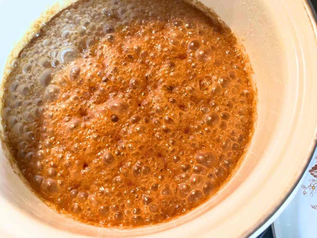 Caramel cooking in a white pot.