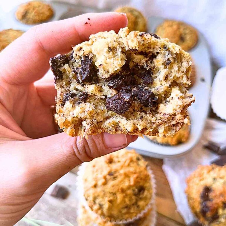 A close up look at the inside of a banana chocolate chunk muffin. A woman is holding the muffin.