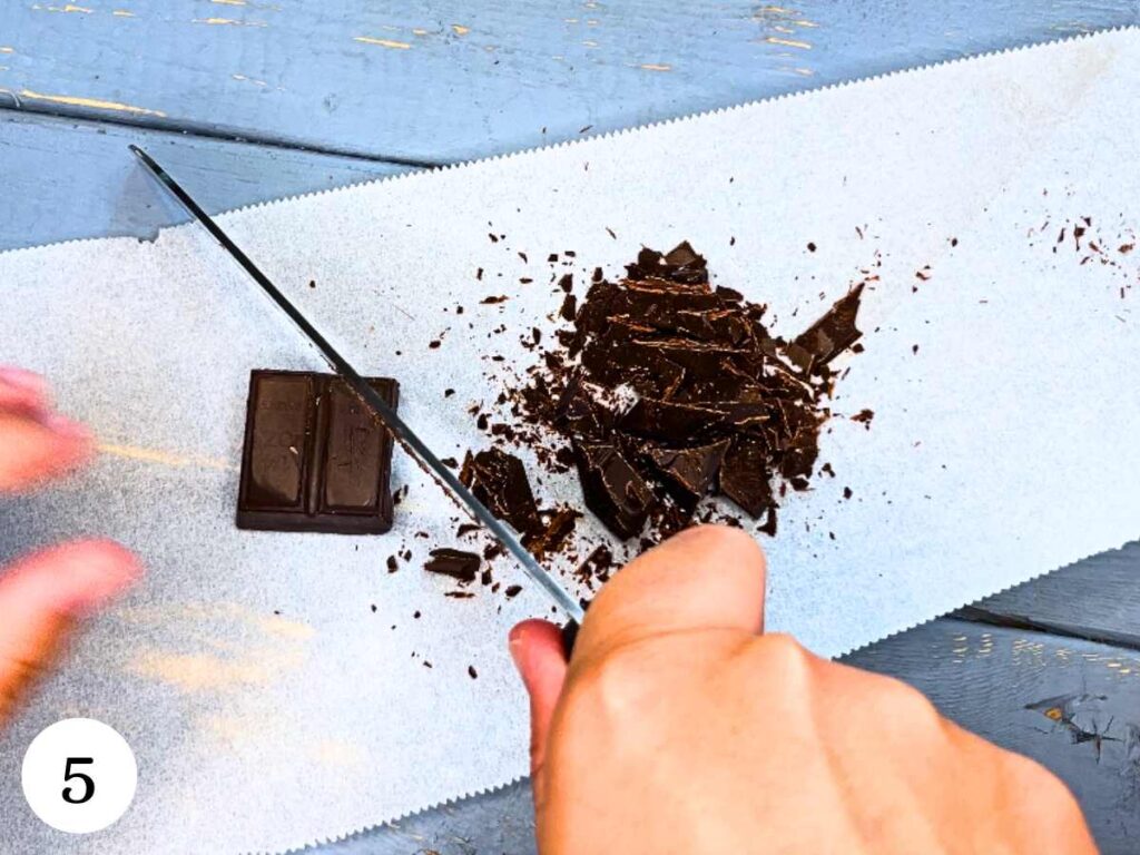 A woman is chopping chocolate.