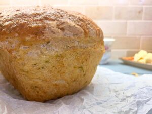 There is a side view of a loaf of bread with zucchini baked inside.