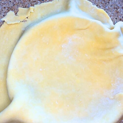 There is pie dough over top of a pie plate.