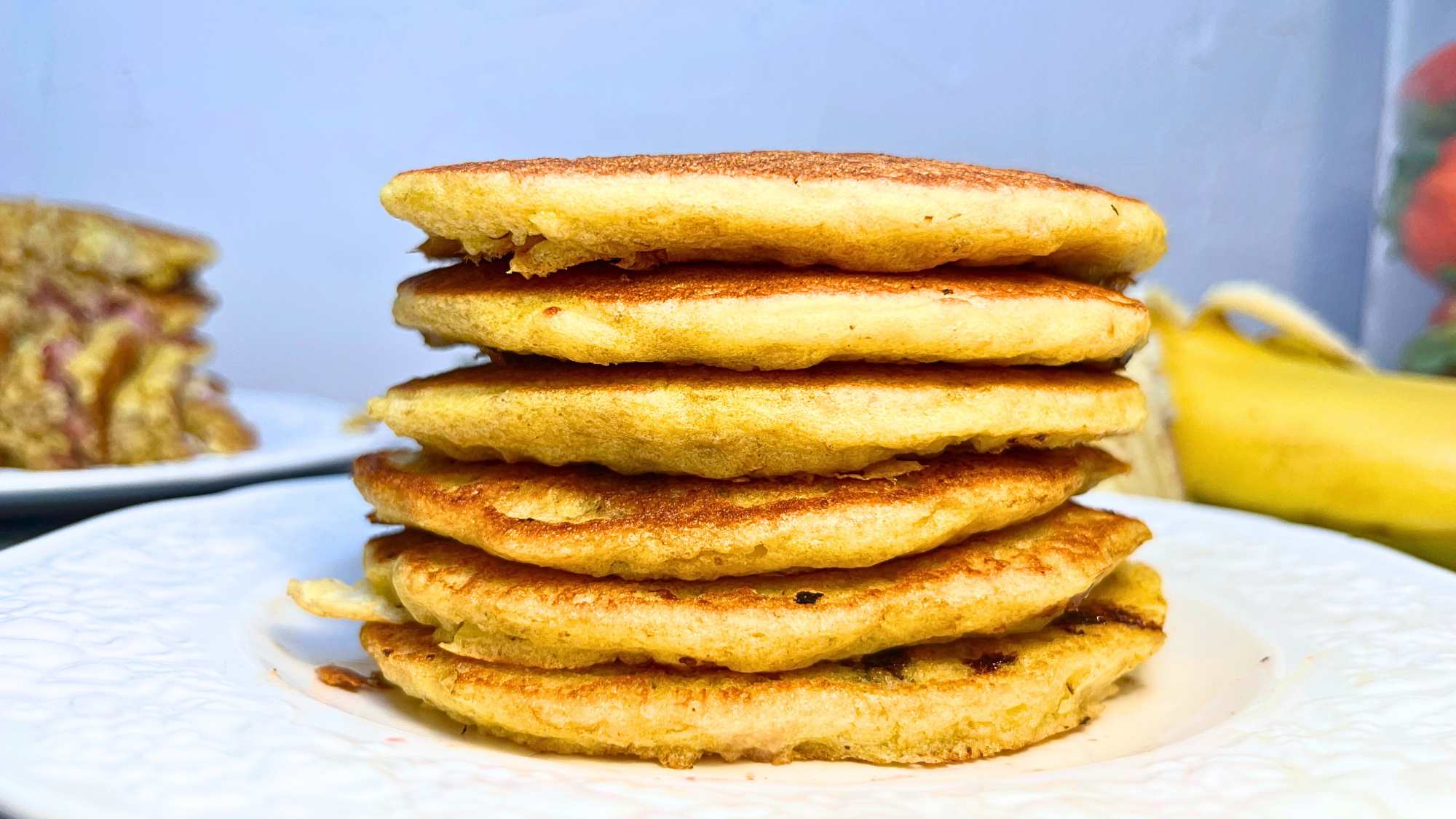 A stack of oatmeal pancakes on a white plate.