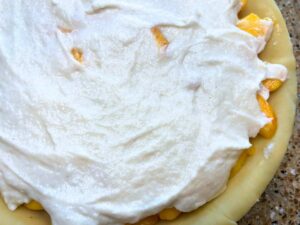 An unbaked pie with a cream layer on top.