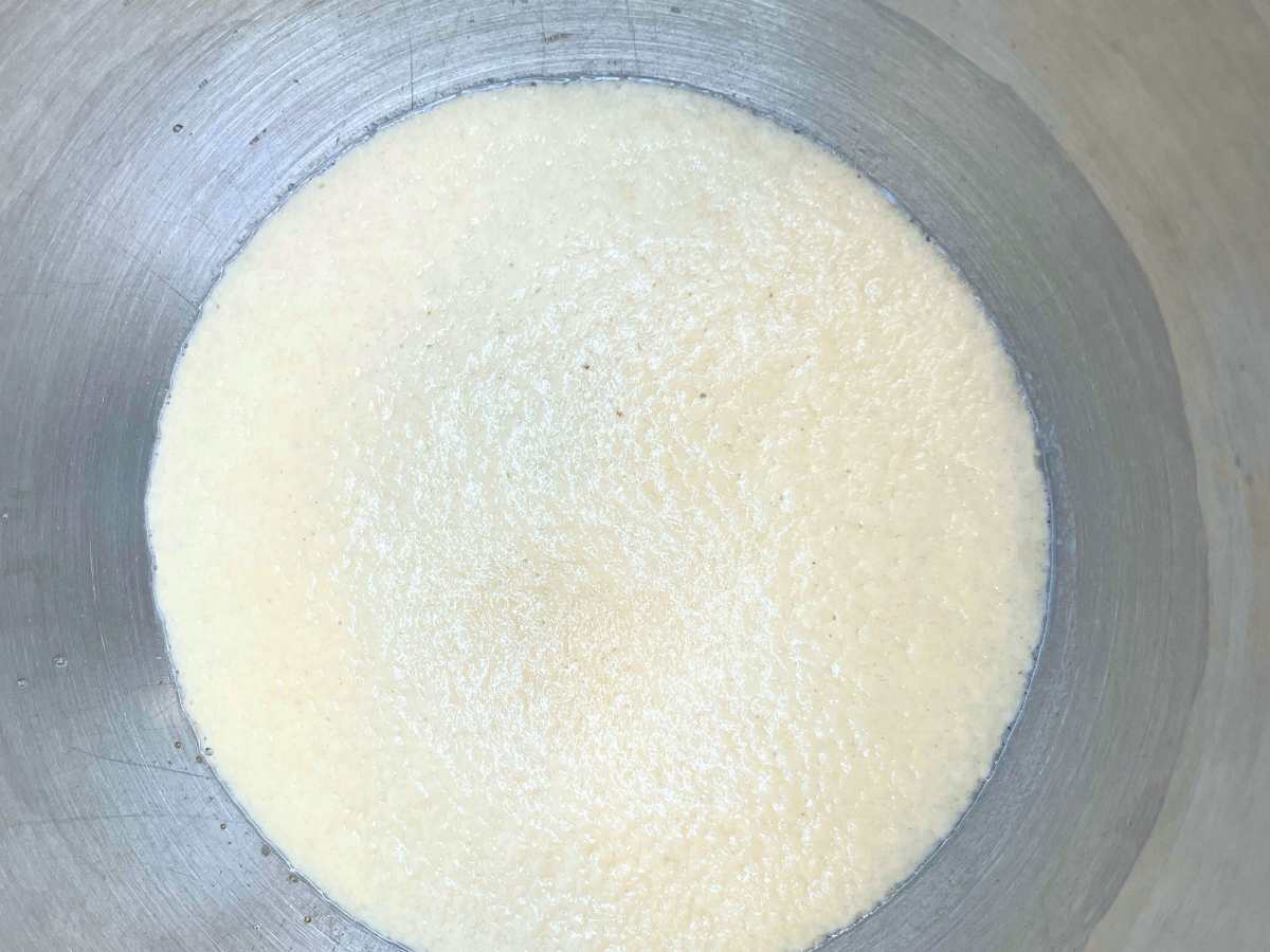 Foamy yeast in a metal bowl.