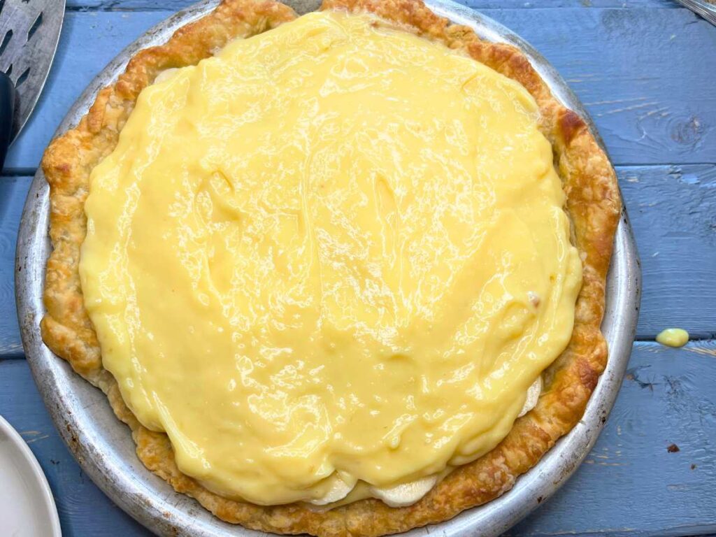 A baked pie crust full of bananas and banana pudding.