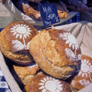 There are loaves of bread with decorative flour flowers on top.