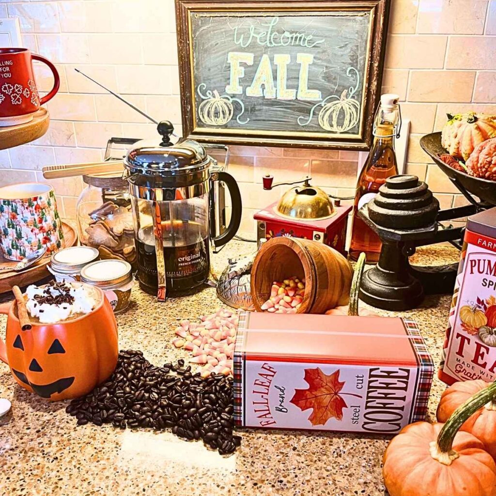 There is a fall themed drink station with coffee, treats, and hot cocolate.