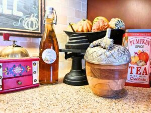 A fall coffee station with with coffee syrup and mini gourds.