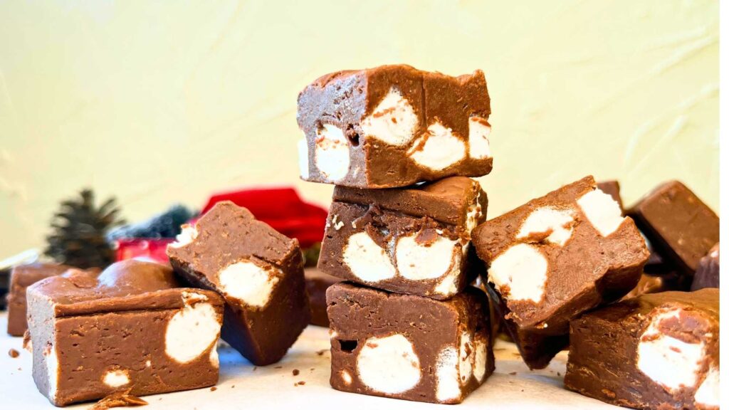 There is a stack of chocolate fudge squares with marshmallows inside.