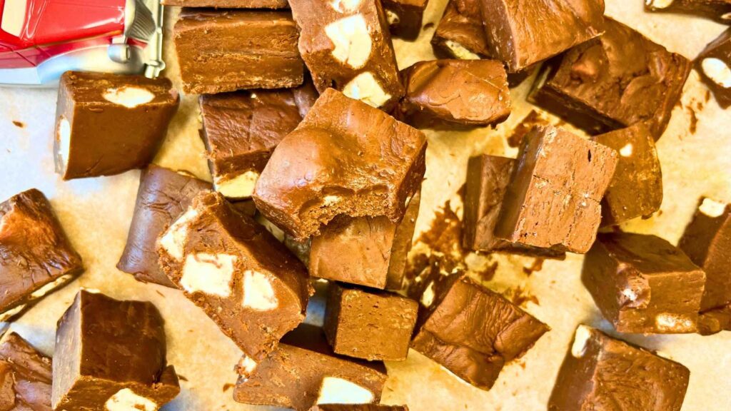 There is a over top view of chocolate marshmallow fudge cut into bite-sized pieces.