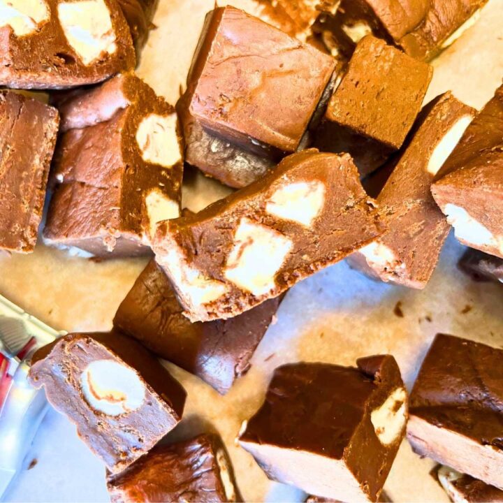 An over top view of pieces of chocolate marshmallow fudge. One piece on top is turned on it's side to show the marshmallows inside.