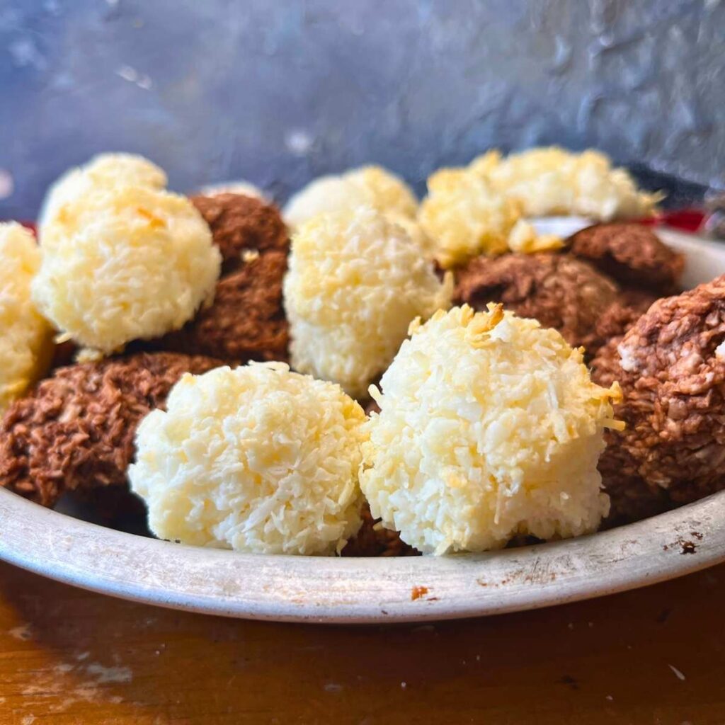 A metal pie plate full of coconut and chocolate macaroons.