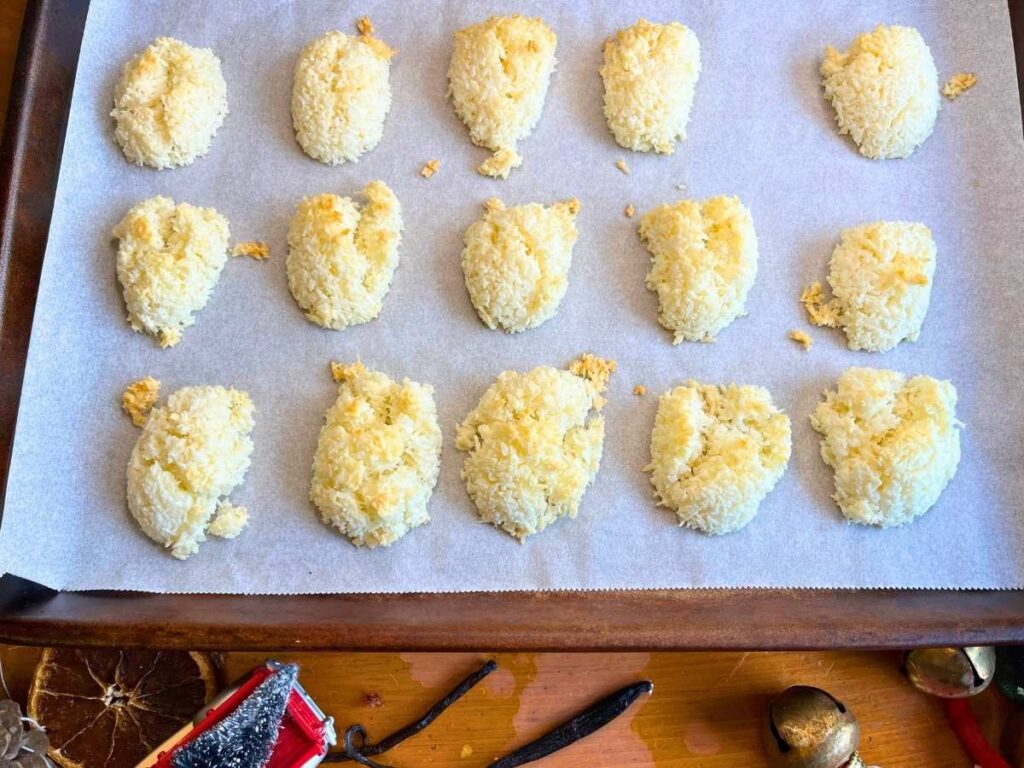 Coconut macaroons on a lined baking sheet.