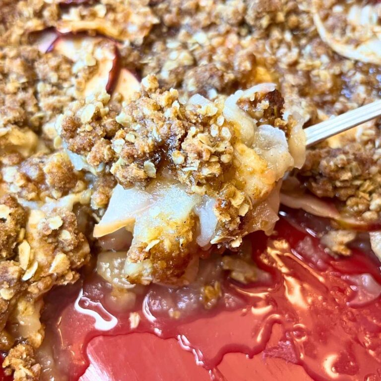 A honey apple crisp in a red casserole dish.