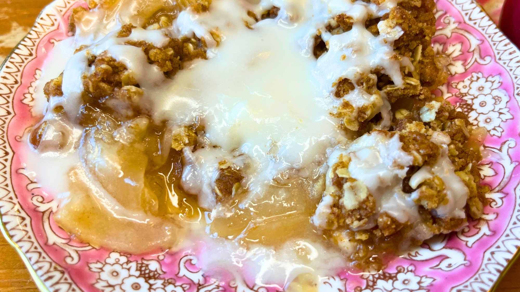 A serving of honey apple crisp with white icing on top.