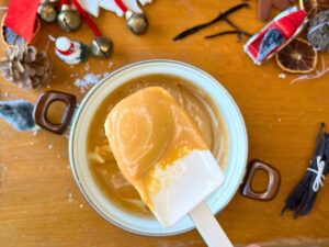 A woman showing caramel on a white spatula.