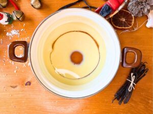 A white pot with sweetened condensed milk and corn syrup inside.