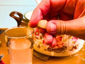 There is a woman holding a piece of caramel between her fingers.