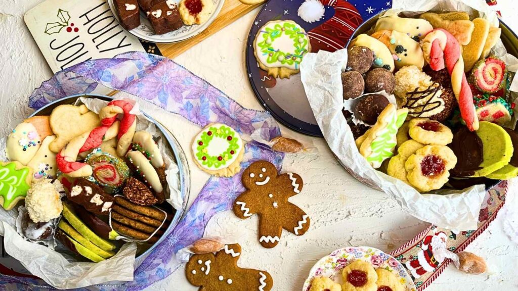 Assorted Christmas cookies arranged in 2 cookie tins.