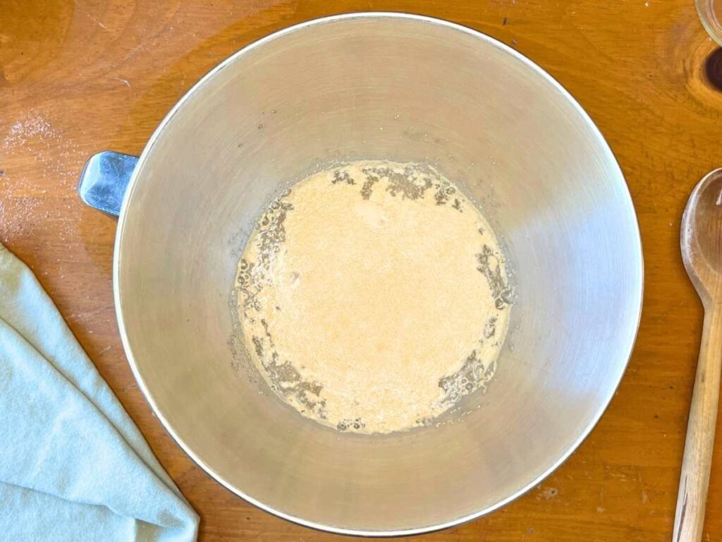 A metal bowl with water and yeast inside.