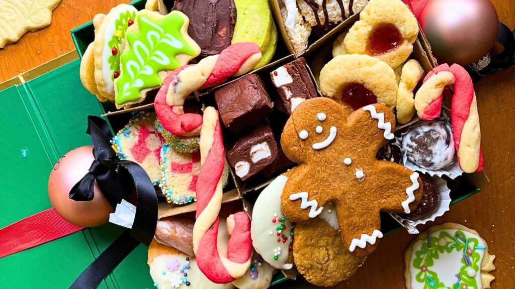 A green box full of assorted Christmas cookies.