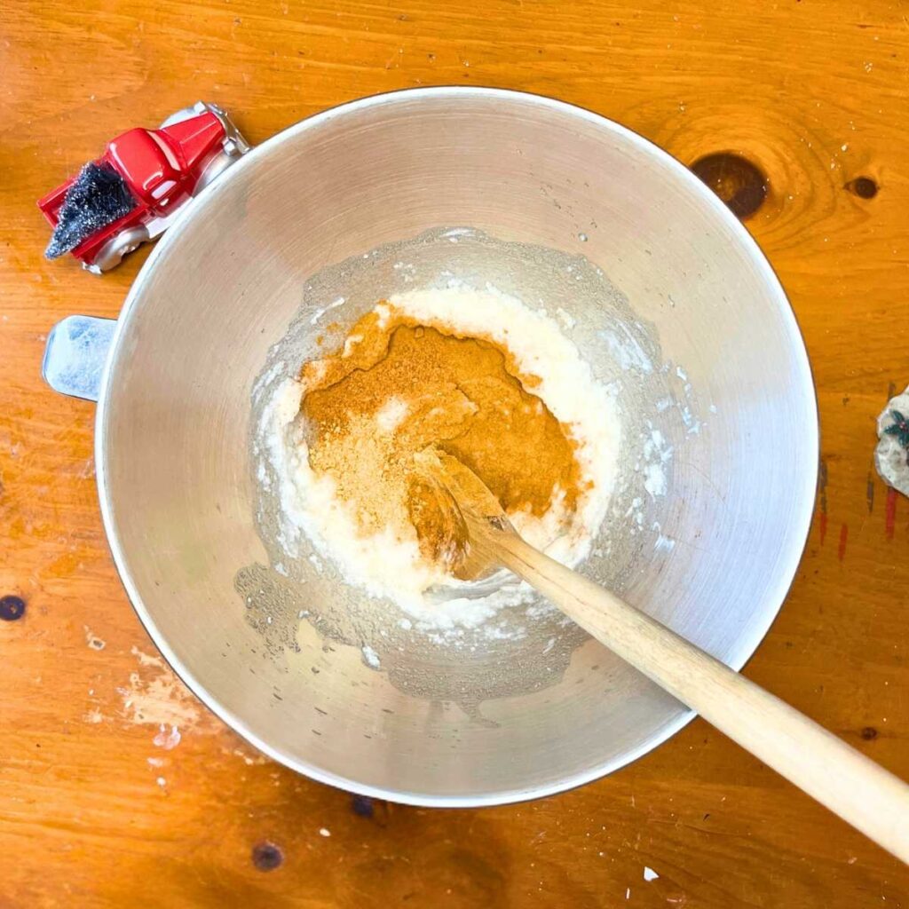 A metal bowl with gingerbread batter and flour inside.