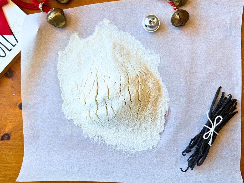 A piece of parchment paper with sifted dry ingredients on top.