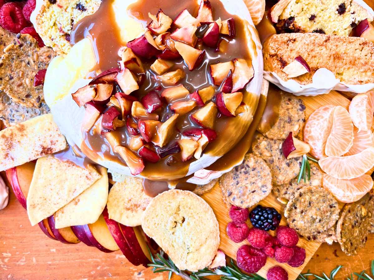 An overhead look at a baked Brie covered in apple caramel sauce.