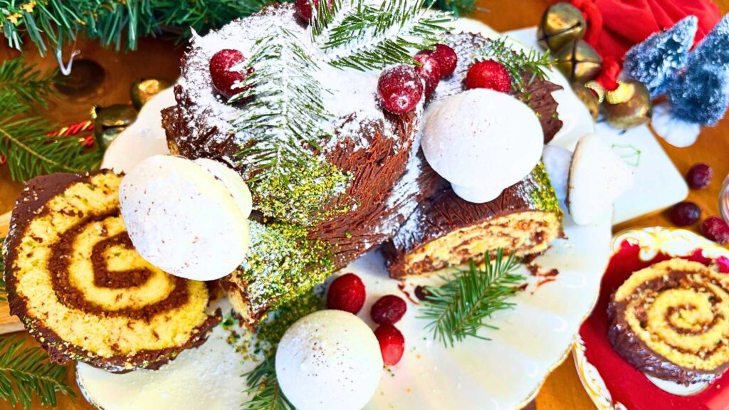 A winter themed chocolate cake decorated with meringue mushrooms, cranberries, and evergreen pieces.