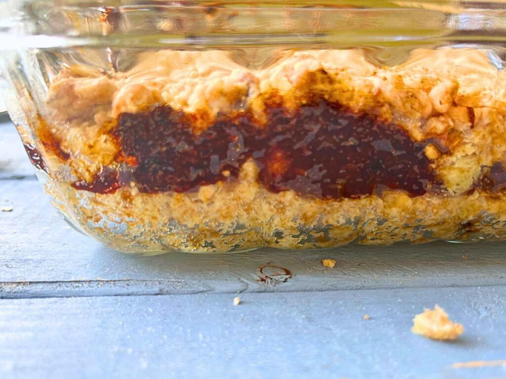 A side view of a casserole dish with date squares insdie.