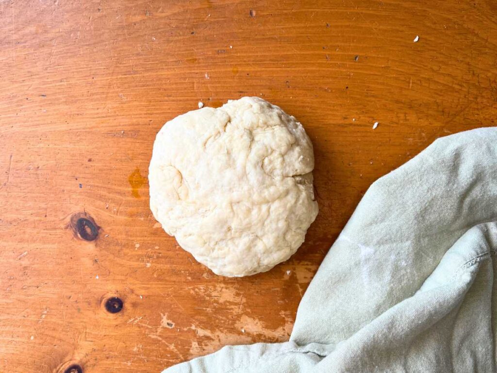 A bannock dough ball on a wooden table.