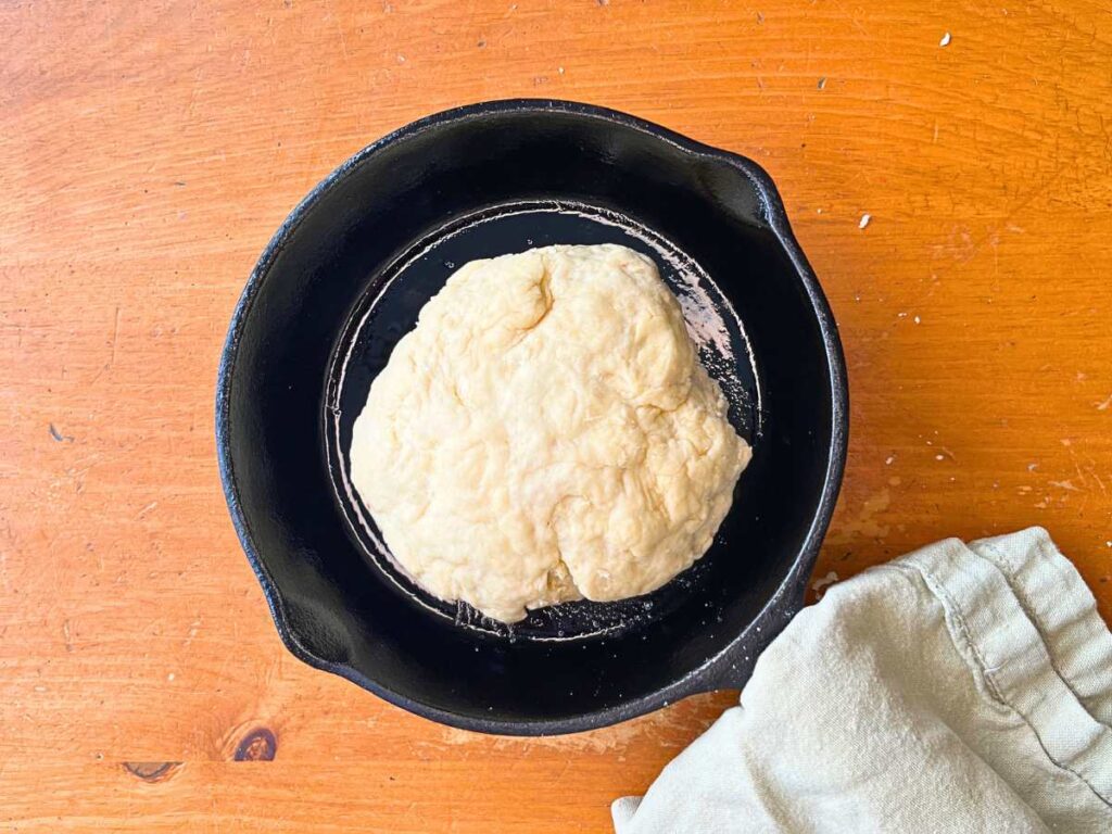 A bannock dough in a black cast iron skillet.