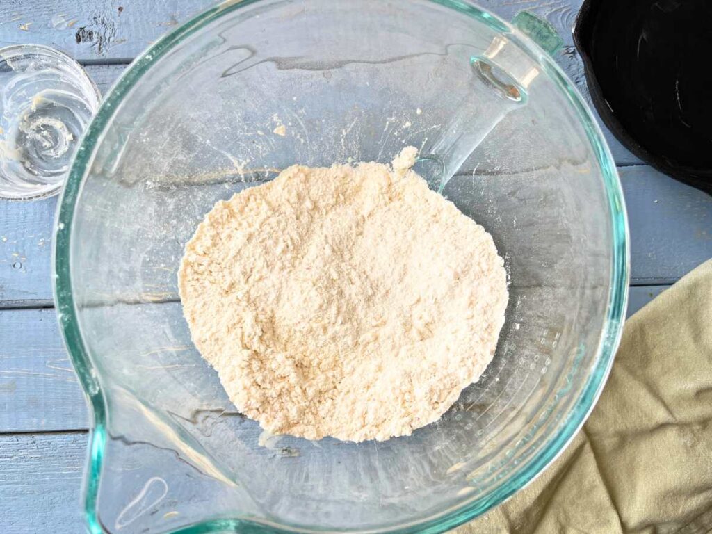 A glass bowl with dry ingredients inside.