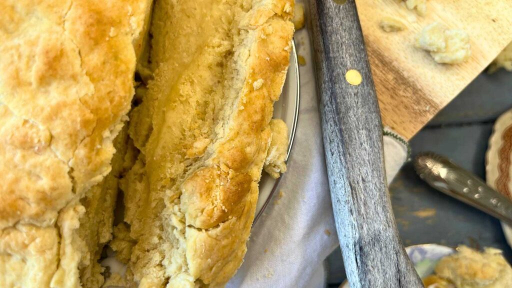 A sliced loaf of bannock bread on a wooden cutting board.