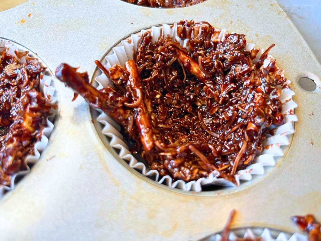 A close up look at a chocolate nest in a lined muffin tin.