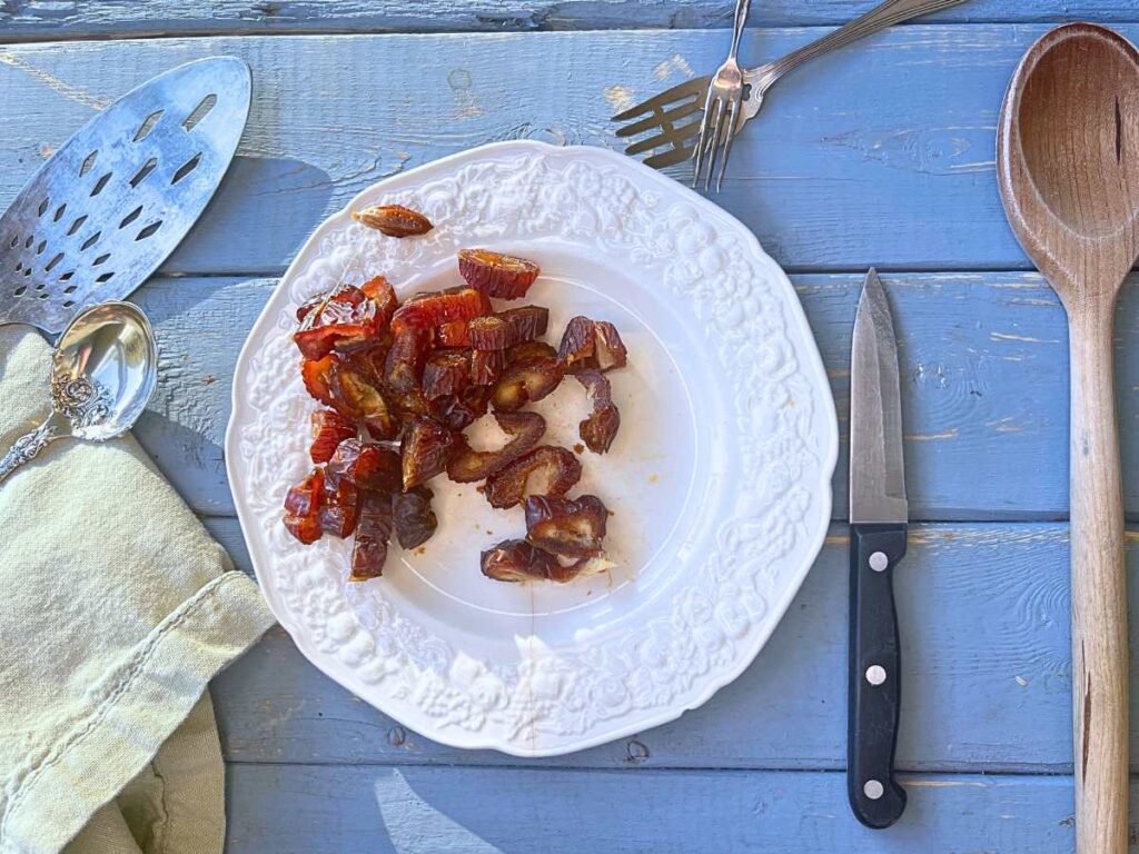 A white plate full of chopped dates.