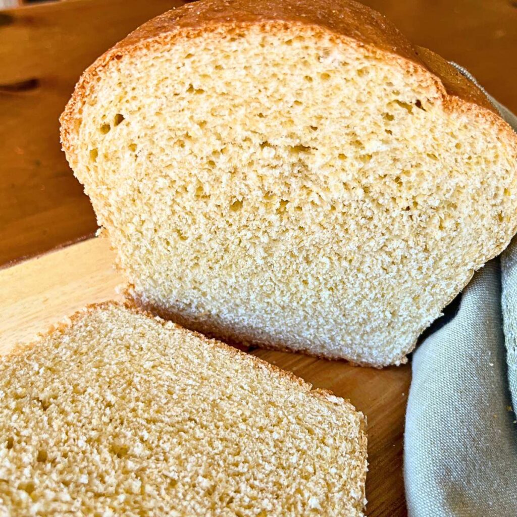 A sliced loaf of cornmeal sandwich bread showing the inside of the loaf.