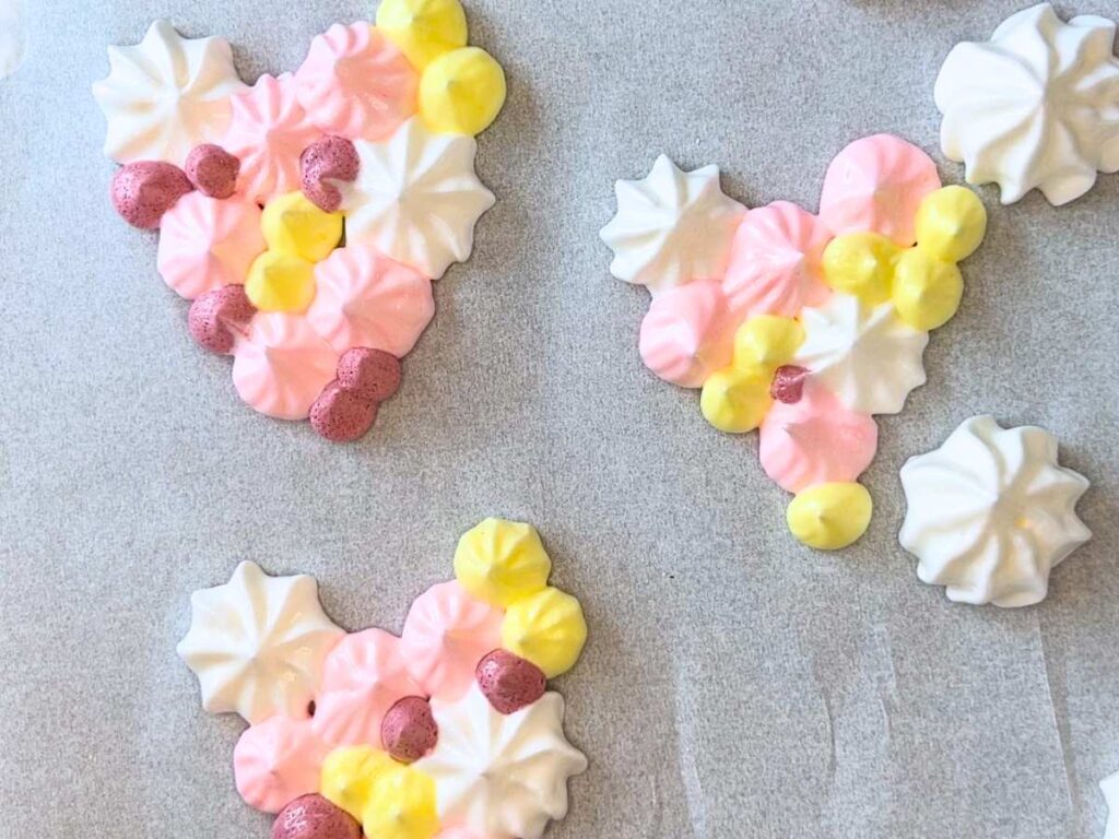 Piped heart meringue cookies with different colours.