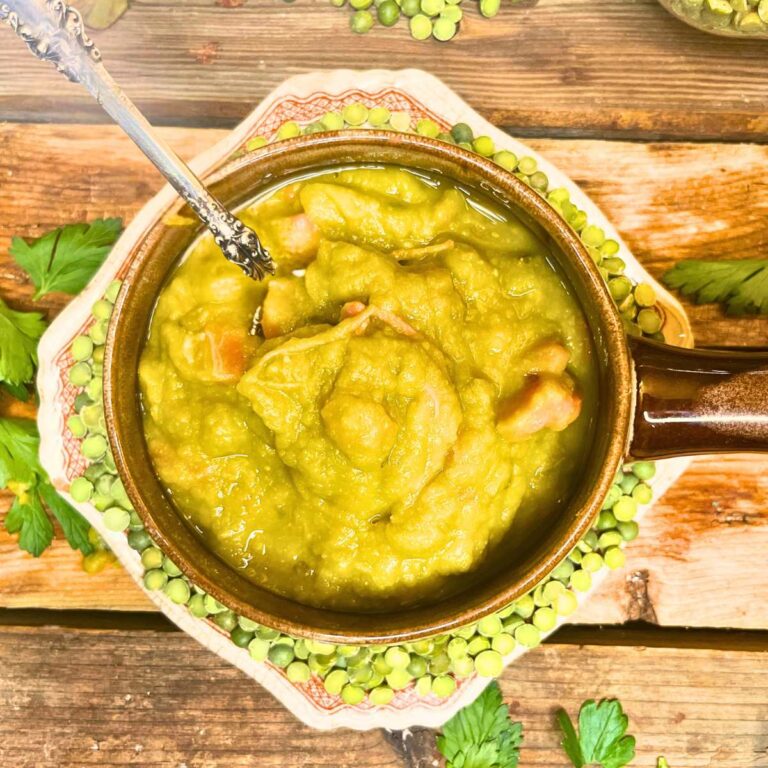 A brown bowl full of split-pea soup. There is a plate underneath with dried peas on it.