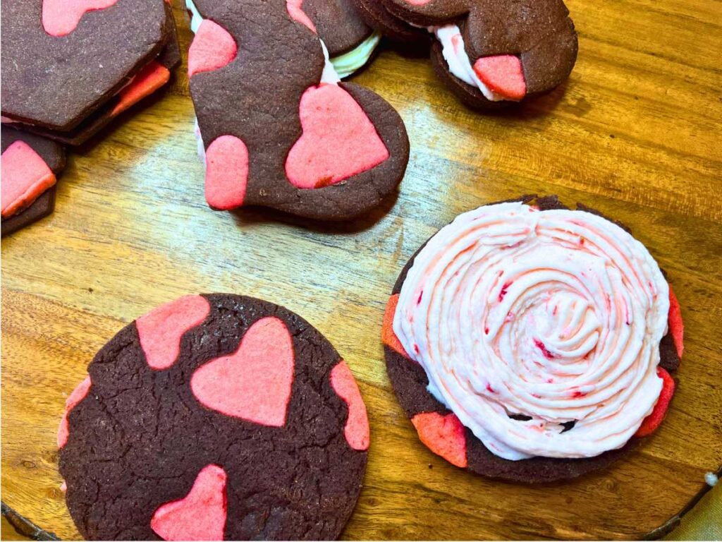 Chocolate and strawberry cookies with some strawberry buttercream spread on one of the cookies.