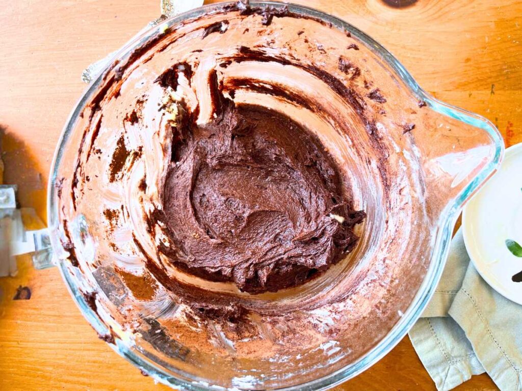 A glass bowl with a chocolate mixture inside.