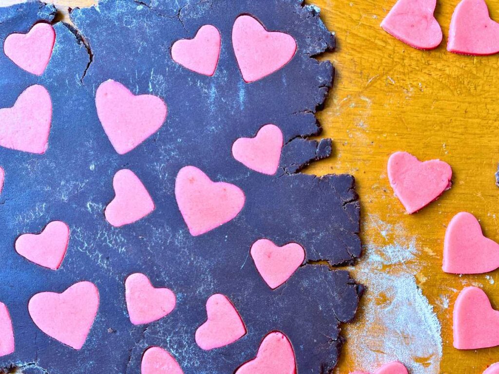 Chocolate cookie dough with pink dough hearts.