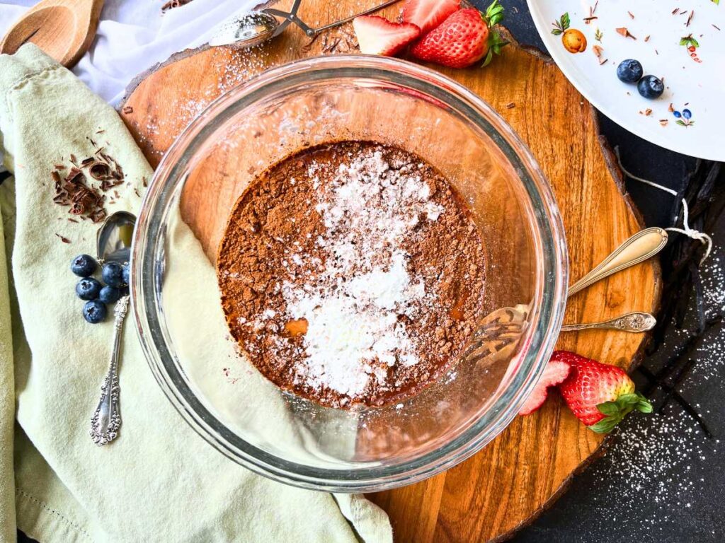 A glass bowl with cocoa and cornstarch mixture inside.