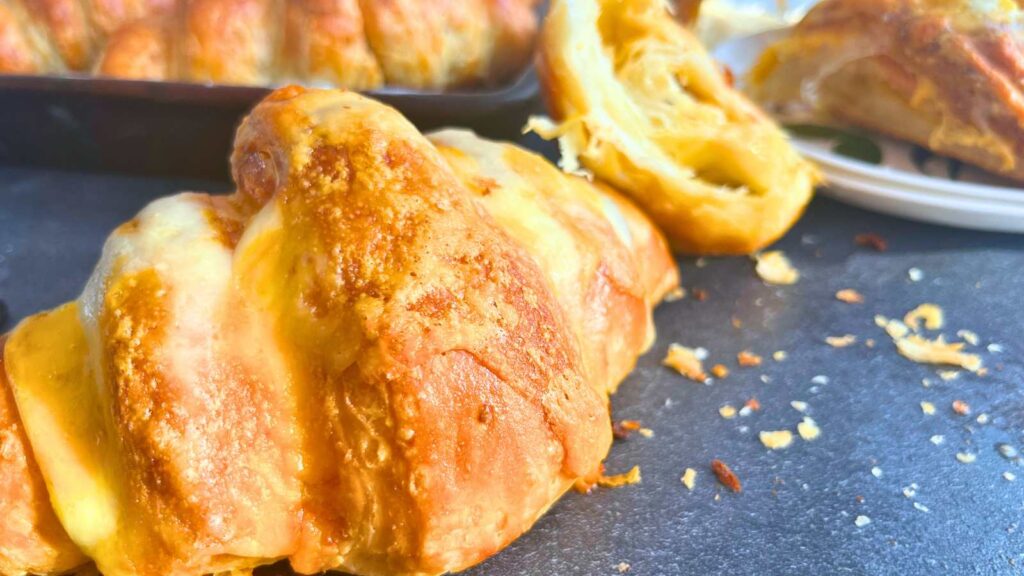 Some cheese croissants on a slate table.