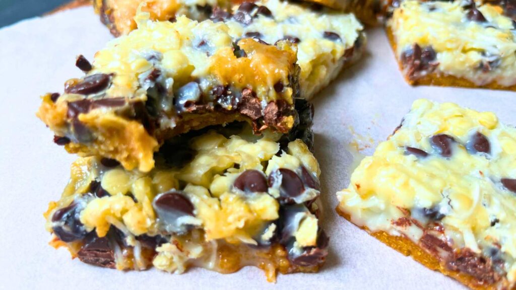 A stack of chocolate and vanilla squares. The top one has a bite out of it.